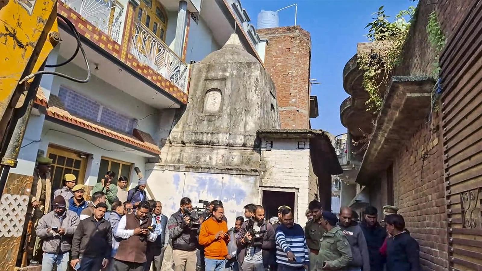 Police personnel and media during the opening of locks of an ancient temple, in Sambhal district, Dec14. (Image source: PTI)